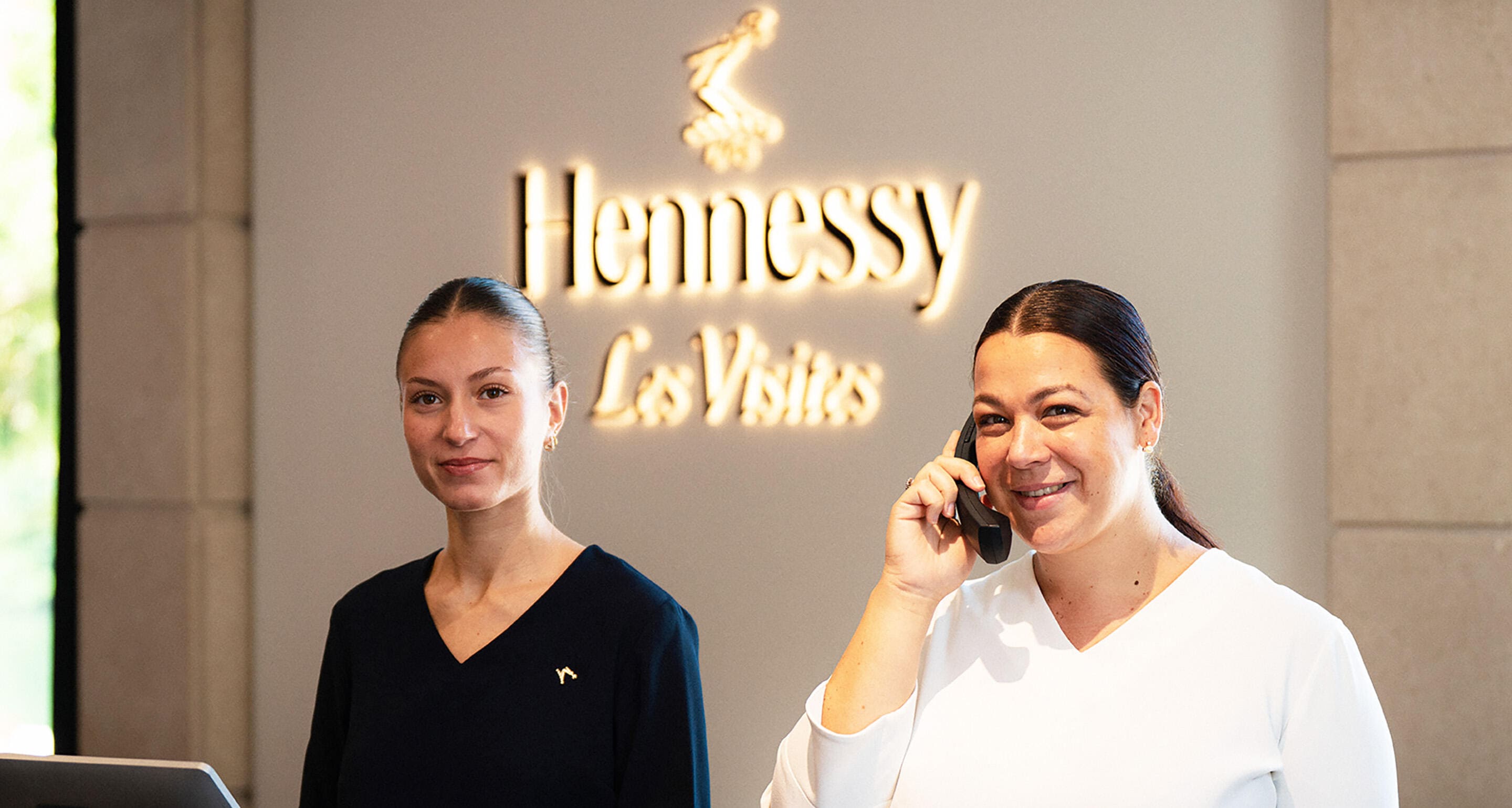 Two young women welcoming guests at the Hennessy Boutique in Cognac