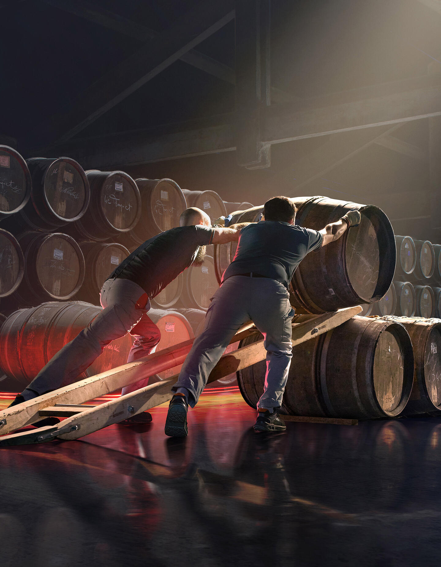 Two Hennessy workers align hundreds of oak barrels in a traditional cellar